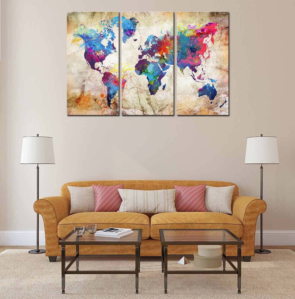 World Map in Paint Spatter: Three-panel canvas art featuring colorful watercolor-style world map with vibrant blue, pink, and purple paint splatters on vintage beige background, displayed above tan couch with decorative table lamps