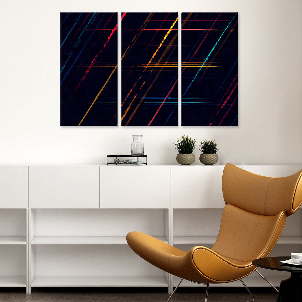Abstract Colors - Modern three-panel wall art featuring vibrant diagonal lines in red, yellow, blue, and turquoise against a deep navy background, displayed above white furniture with decorative plants
