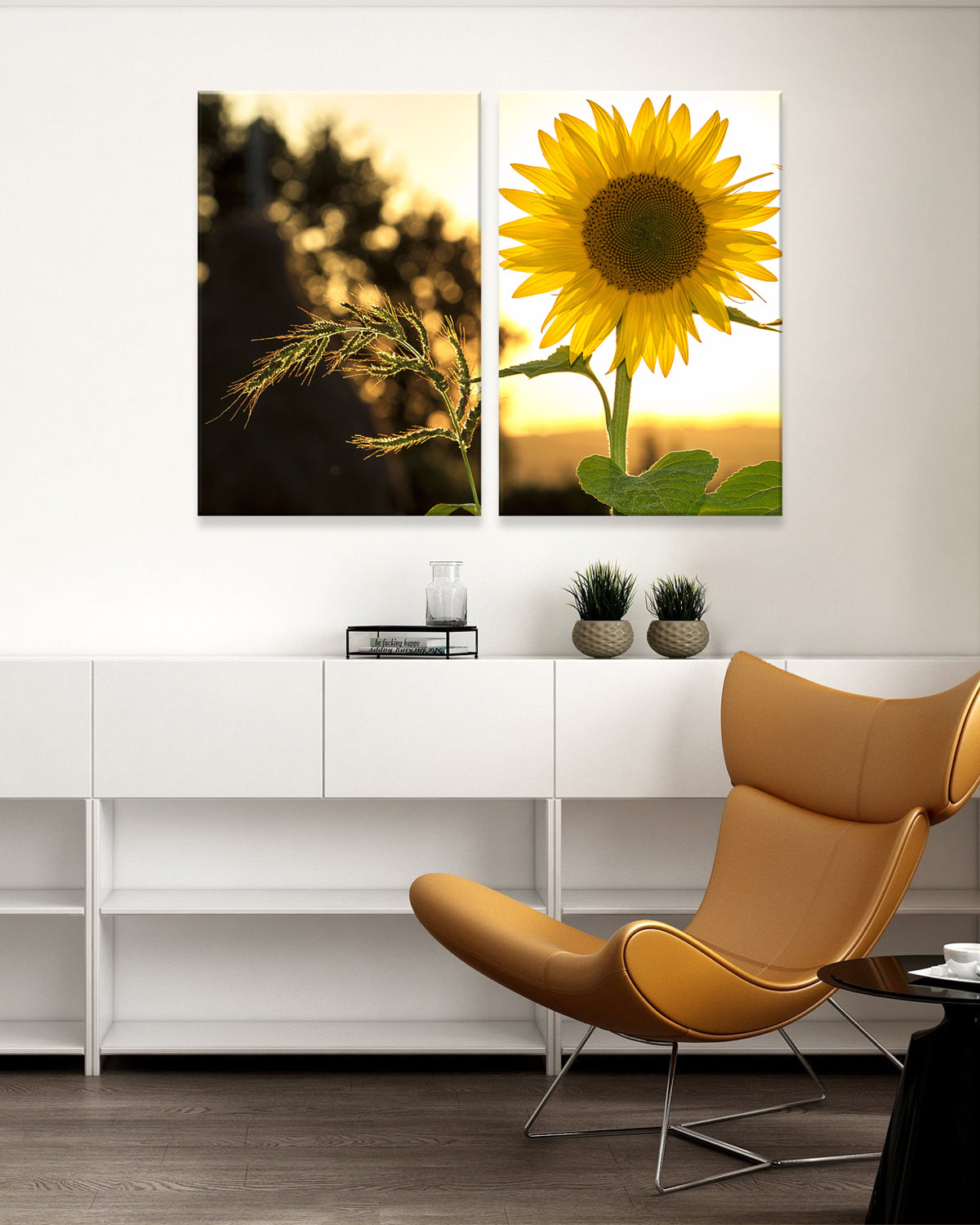 Backlit Sunflower - Two-panel canvas print featuring a vibrant yellow sunflower in golden sunset light, paired with silhouetted wheat stalks against a warm evening sky. Modern wall art displayed above white furniture in contemporary room setting.
