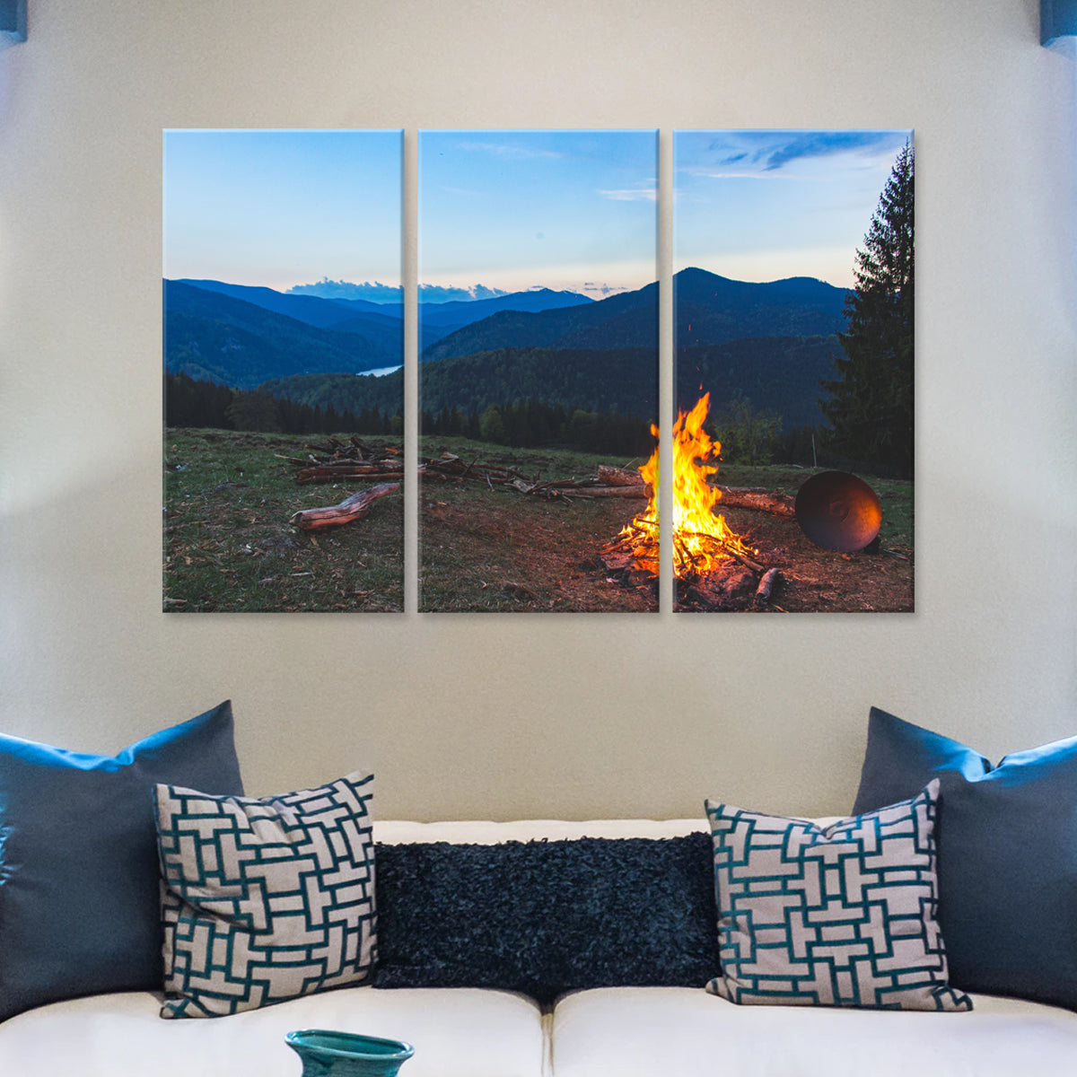 Campfire: Three-panel canvas art displaying a vibrant campfire glowing against a stunning mountain landscape at dusk, with snow-capped peaks in the background and blue mountain silhouettes stretching across the horizon