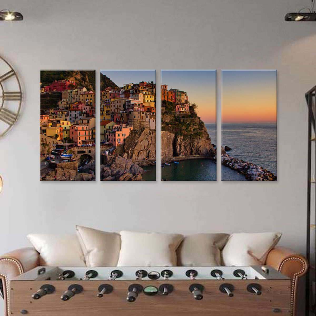 Cinque Terra 4-panel canvas wall art featuring colorful coastal buildings perched on cliffs at sunset, overlooking the Mediterranean Sea in Italy, displayed above a contemporary living room sofa