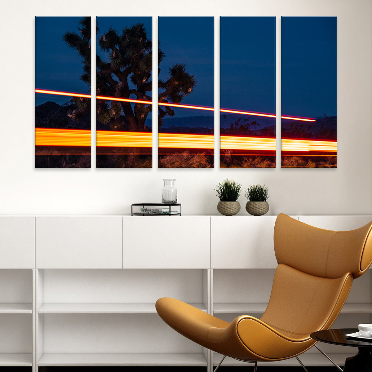 Joshua Tree 5-panel canvas wall art featuring desert landscape at dusk with light trails and silhouetted palm trees against deep blue sky, mounted above modern white furniture