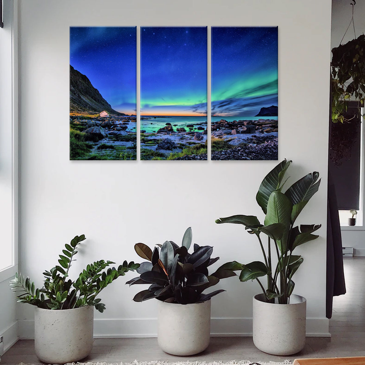 Northern Lights canvas print featuring a stunning aurora borealis display over a rocky coastal landscape at night, with vibrant green and blue lights dancing across a starlit sky, displayed as a 3-panel wall art set