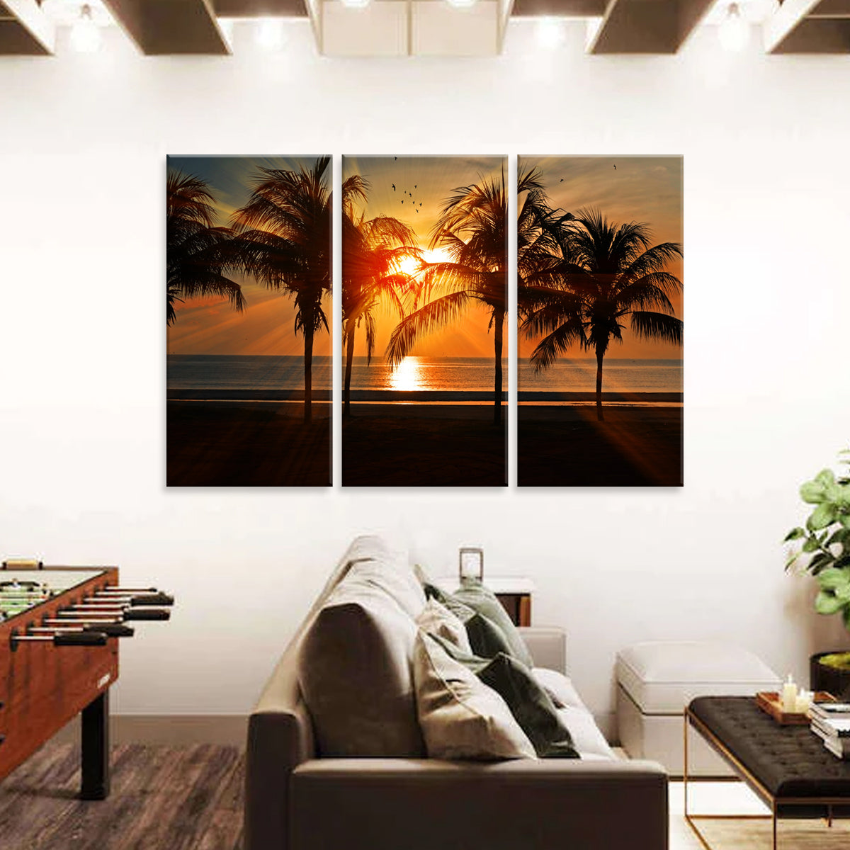 Sunset Beach wall art - 3-panel canvas print featuring a vibrant orange sunset behind silhouetted palm trees on a tropical beach, with birds flying across the horizon, perfect for home decor
