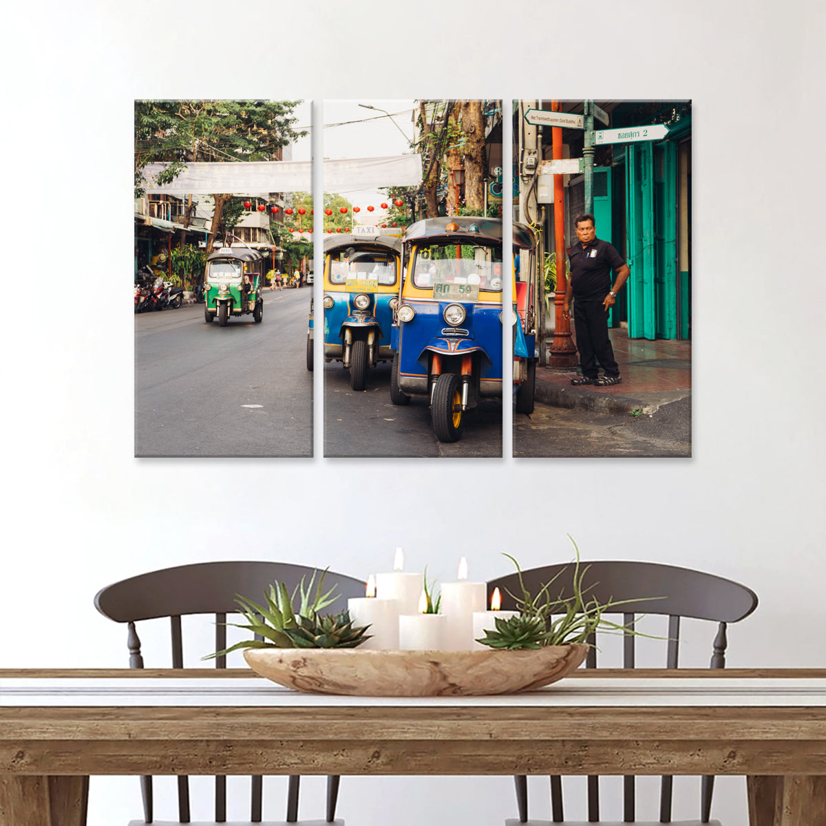 Tuk Tuk canvas wall art featuring colorful three-wheeled auto rickshaws parked on a vibrant urban street, with a green tuk tuk visible in the background and traditional architecture creating an authentic Asian cityscape atmosphere