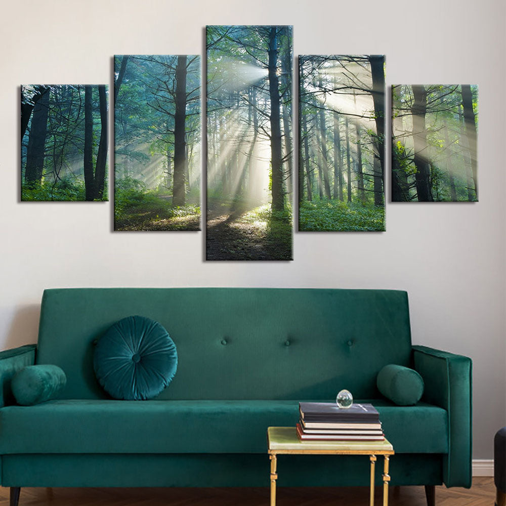 Tranquil Forest Scene: 5-panel canvas wall art depicting sunbeams piercing through misty woodland, creating ethereal rays of light between tall trees on a forest path, set in rich emerald and jade tones