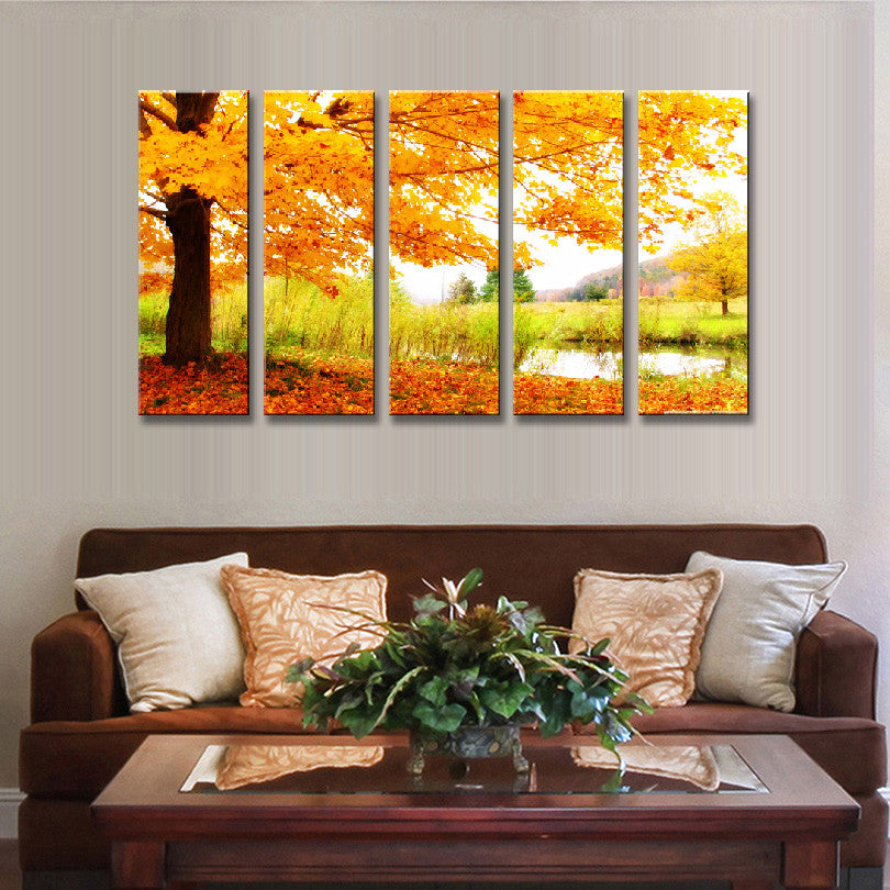 Maple Tree Fall Landscape: 5-panel canvas wall art featuring vibrant orange autumn maple tree with falling leaves beside a tranquil pond, set against a golden sunrise in a serene natural setting