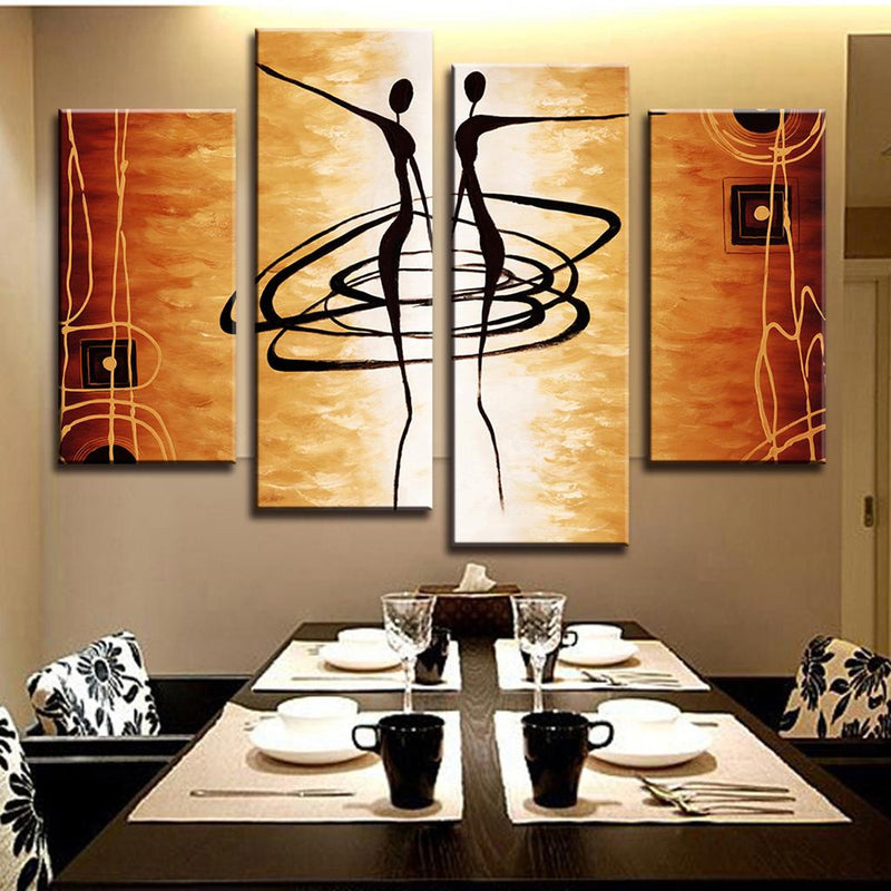 Abstract Dancers wall art featuring minimalist black silhouettes dancing in a spiral pattern against warm orange and golden tones, displayed as a 4-panel canvas set in modern dining room setting