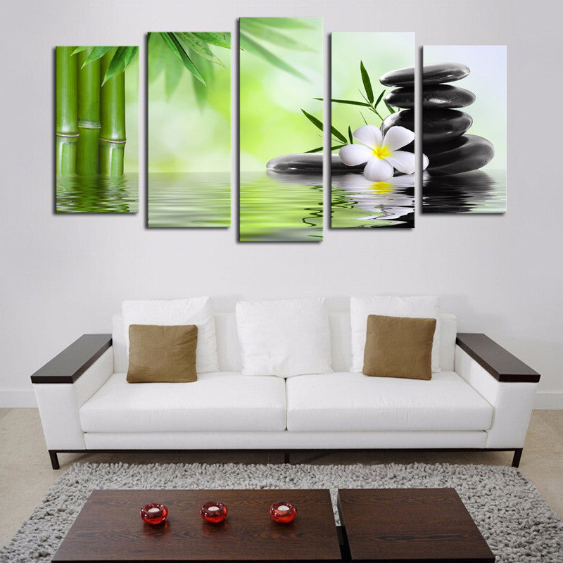 Bamboo Stone Scenery: 5-panel canvas wall art featuring zen elements of green bamboo stalks, black hot stones, white plumeria flower, reflecting in calm water against a soft green background, creating a peaceful spa-like atmosphere
