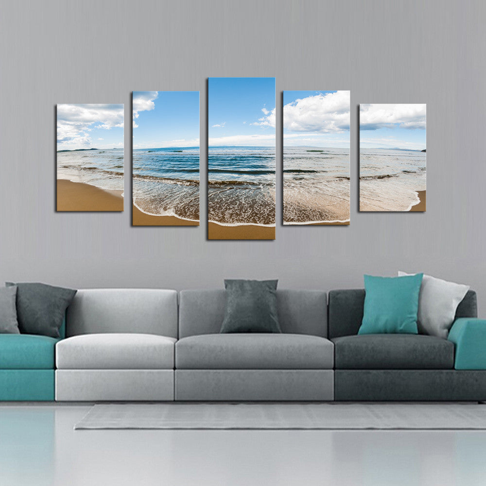 Sprawling Beach - 5 panel canvas wall art featuring a serene beach landscape with gentle waves rolling onto golden sand under a bright blue sky with scattered white clouds, perfect for coastal home decor