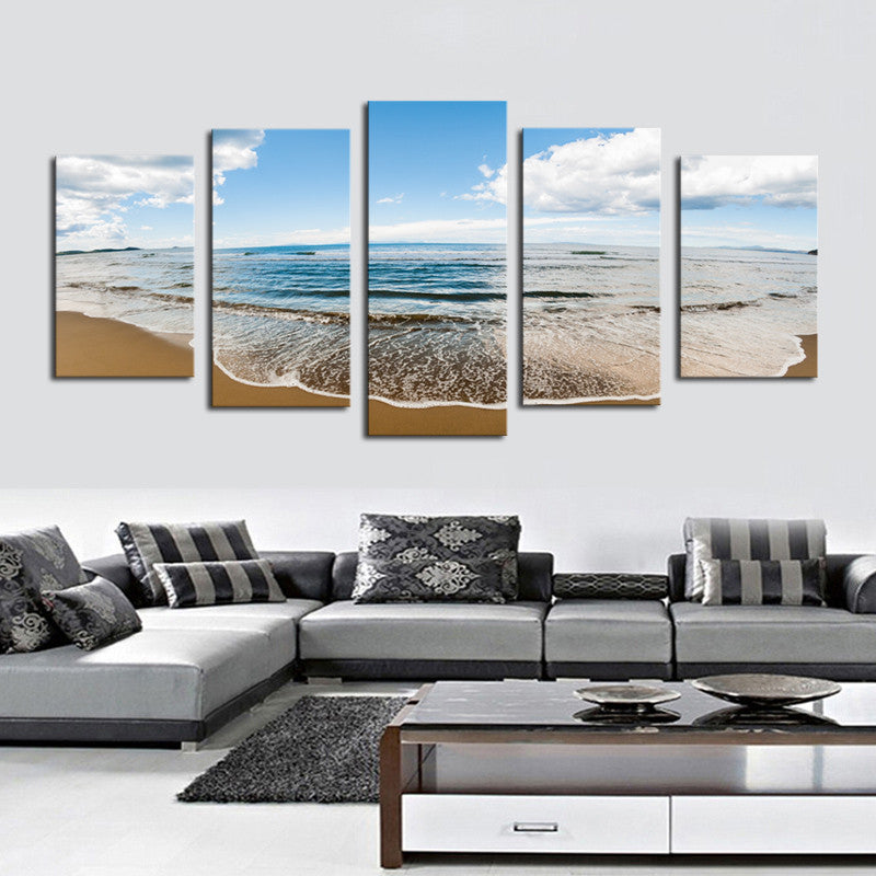 Sprawling Beach canvas print features a serene ocean scene with gentle waves meeting golden sand under a bright blue sky with white clouds, split into 5 panels creating a panoramic coastal view