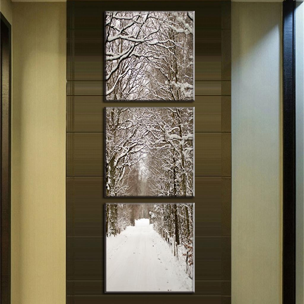 Snowy Winter Boulevard - Three-panel canvas art displaying a serene snow-covered tree-lined path, with snow-laden branches forming a natural archway over a peaceful winter walkway