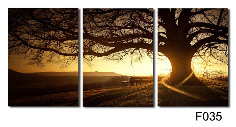 Tree in the Sunset - Majestic old tree silhouette against golden sunset sky, 3-panel canvas wall art print featuring a solitary bench under sprawling branches, dramatic landscape photography in warm sepia tones