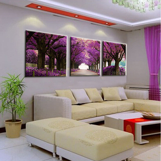 Purple Tree Path canvas wall art showing enchanting pathway lined with vibrant purple cherry blossom trees, displayed as 3-panel modern home decor in contemporary living room setting