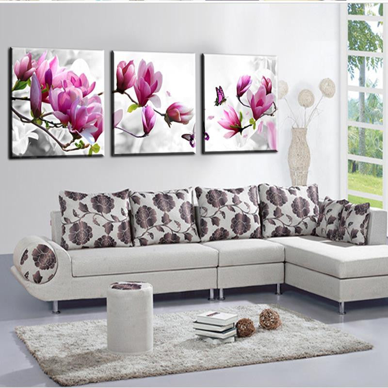 Flowers and Butterflies wall art featuring three-panel canvas prints of pink magnolia blossoms with purple butterflies against white background, perfect for modern home decor and living room walls
