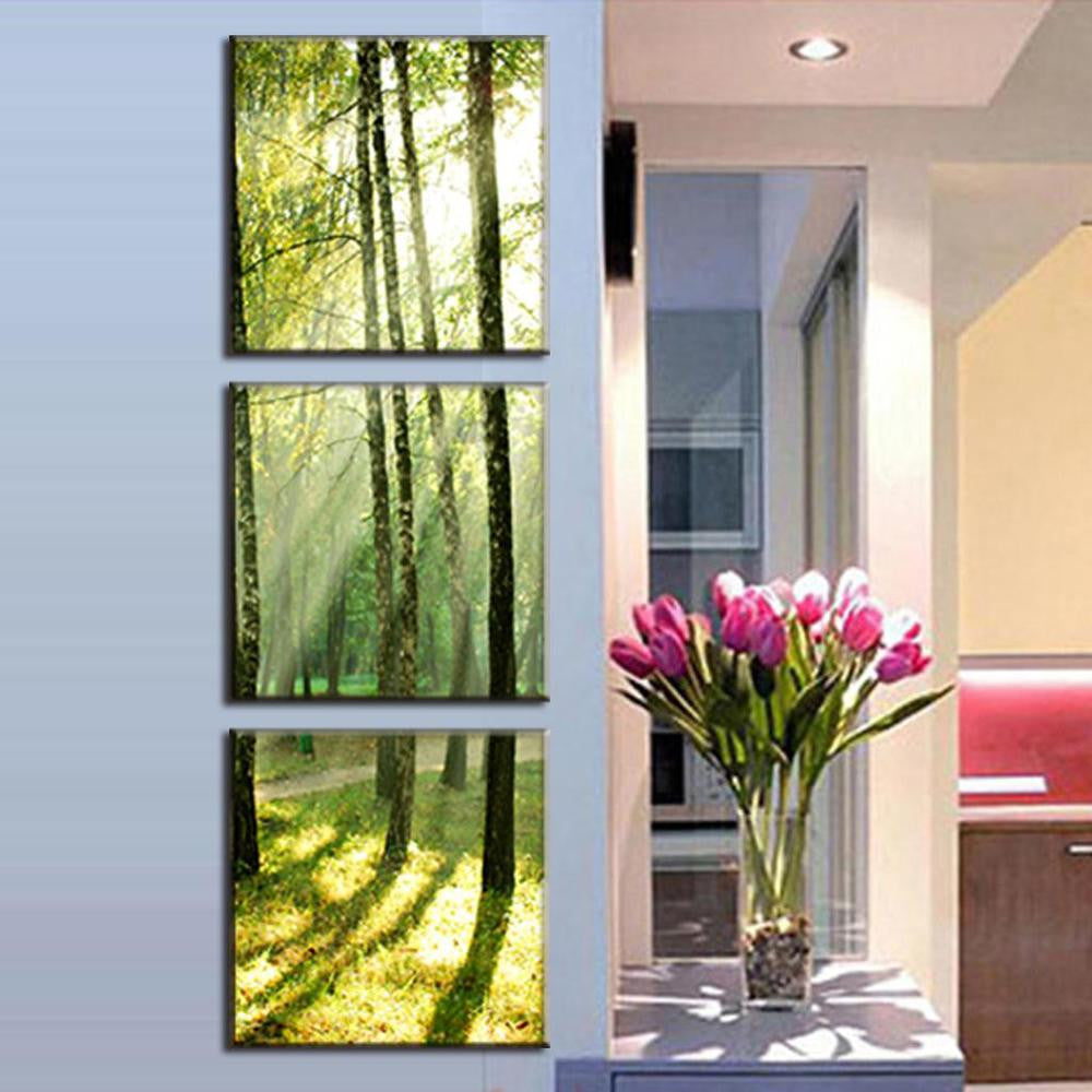 Sunshine Through the Trees: Three-panel canvas wall art displaying sunlight filtering through forest trees creating ethereal green and golden rays, shown in modern home setting with decorative tulips