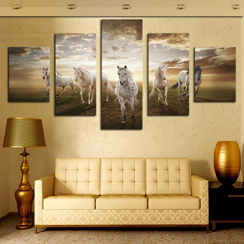 Beautiful Running Horses - Five panel canvas wall art depicting majestic white horses galloping across a grassy field at sunset with dramatic golden sky and cloud formation, showcasing freedom and natural beauty in 60x32 inches total size
