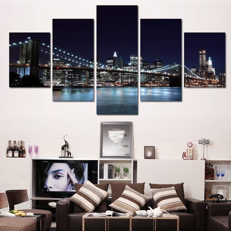 New York City Skyline - 5-panel canvas wall art featuring illuminated Brooklyn Bridge at night with glittering Manhattan skyline, reflecting city lights on calm East River waters, perfect urban decor piece