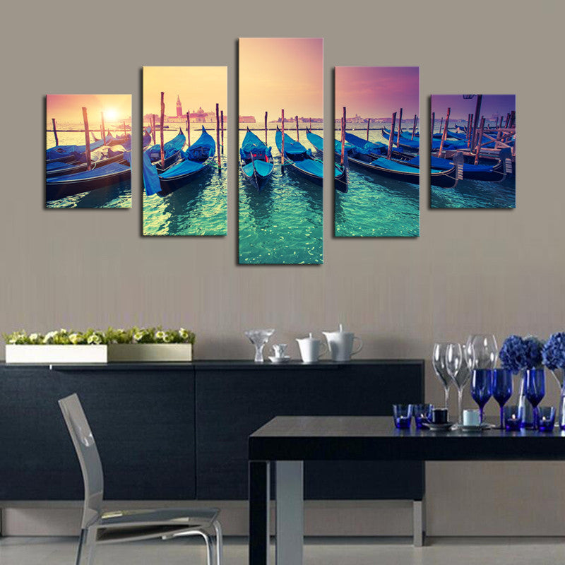 Boats in the Sunset - 5 Piece canvas wall art showcasing vibrant blue gondolas moored in Venice's harbor against a stunning sunset sky, with emerald waters and wooden posts creating a dreamy Mediterranean atmosphere