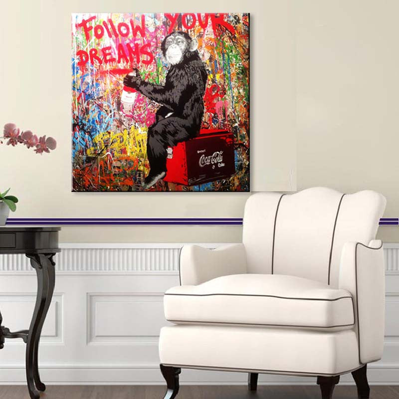 Follow Your Dreams Monkey - Banksy canvas art featuring a black monkey sitting on a red Coca-Cola crate against a vibrant graffiti wall with colorful splashes and 'Follow Your Dreams' text in red, perfect for modern home decor