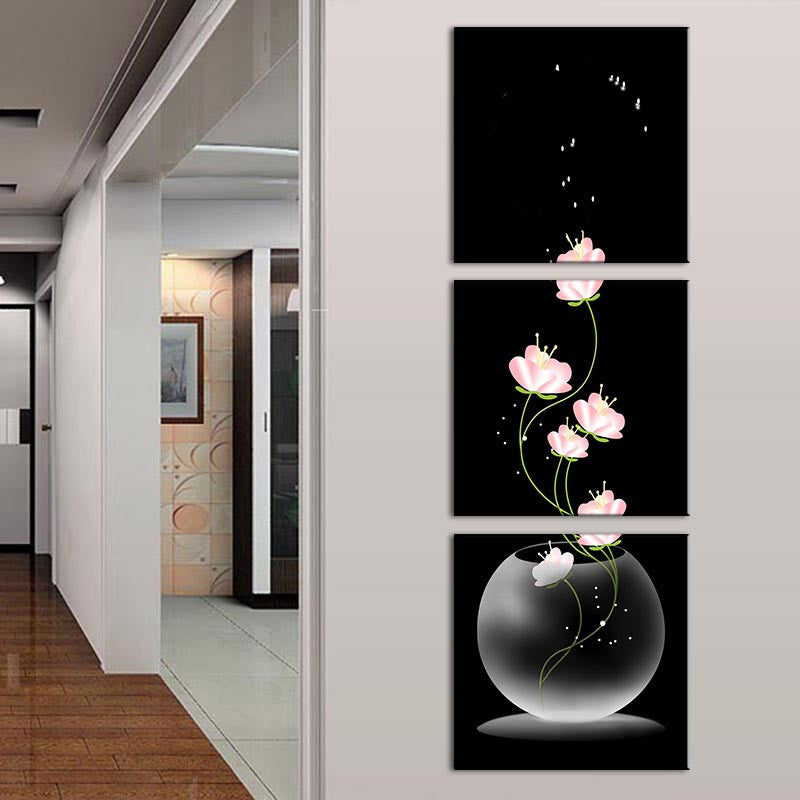 Fishbowl and Flowers - Elegant triptych canvas panel art featuring delicate pink flowers emerging from a glass fishbowl against a black background, with floating sparkles creating a magical effect. Modern wall decor perfect for home or office.
