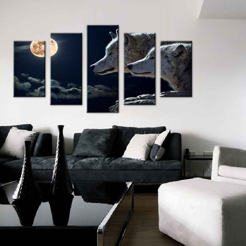 Wolves and Moon at Night canvas wall art featuring a 5-panel split scene of gray wolves gazing beneath a luminous full moon in a dark night sky, displayed above modern living room furniture