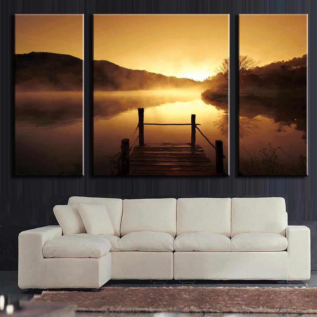 Sunset on the Dock canvas wall art showing serene lake view with wooden pier silhouetted against golden sky, misty mountains reflecting in calm water, perfect for home decor, split into three panels measuring 56x28 inches total