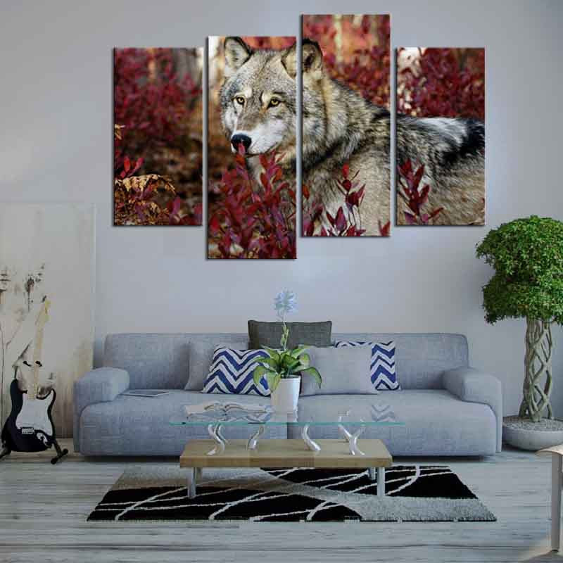 Wolf and Red Leaves canvas wall art featuring a majestic gray wolf amid vibrant crimson autumn foliage, split into four panels displayed above a modern gray sofa in a contemporary living room setting