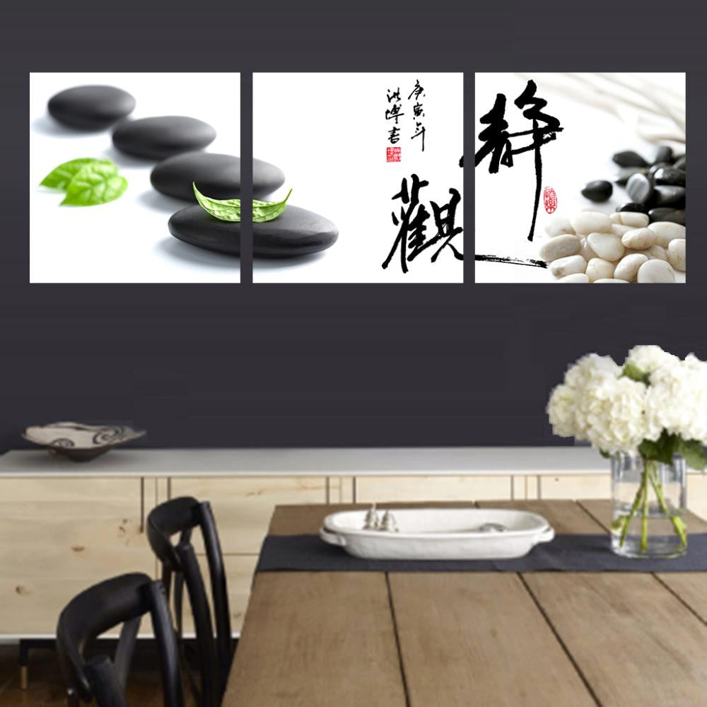 Stone and Leaf with Calligraphy - Zen-inspired triptych wall art featuring black stones with green leaves, Asian calligraphy characters, and white pebbles on canvas panels for peaceful home decor