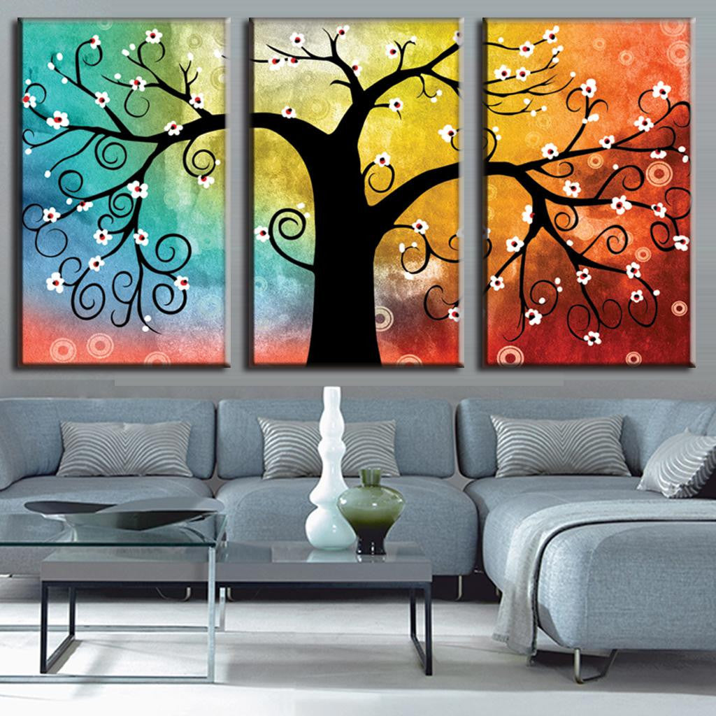 Tree with Abstract Design wall art featuring silhouette of curvy tree with white blossoms against vibrant rainbow gradient background, displayed as three-panel canvas set perfect for modern home decor