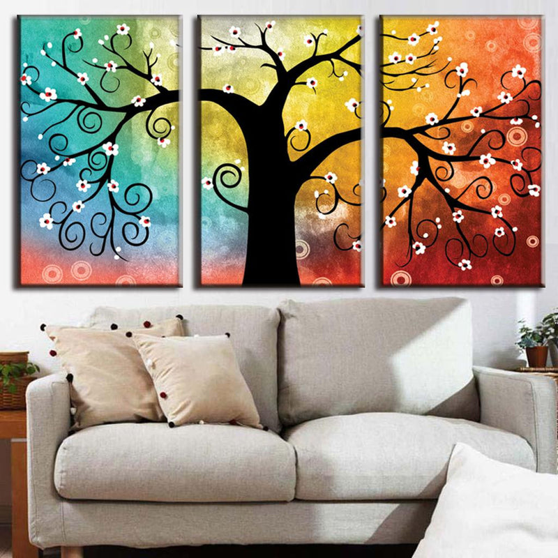 Tree with Abstract Design - 3-panel canvas wall art featuring a whimsical silhouetted tree with swirling branches and white blossoms against a vibrant rainbow gradient background transitioning from turquoise to yellow to orange.