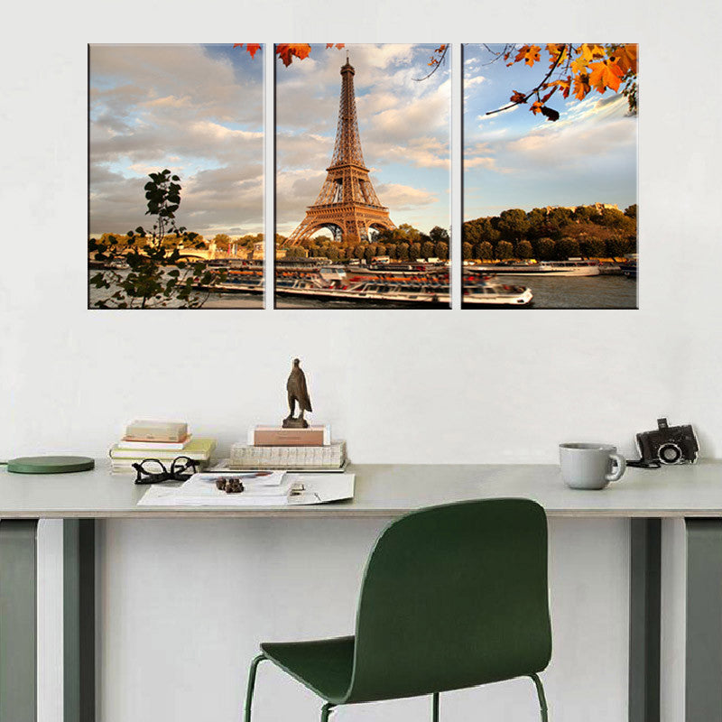 The Eiffel Tower Landscape: Stunning 3-panel canvas artwork featuring iconic Paris landmark at sunset, with autumn leaves framing tower against cloudy sky, Seine river with boats below, perfect wall decor for home or office