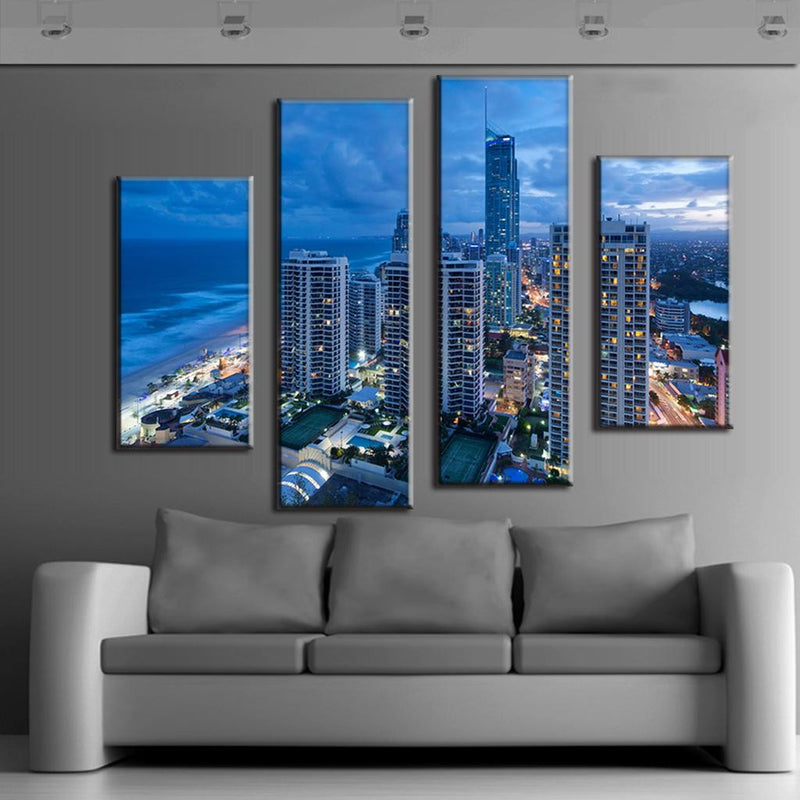 Blue Cityscape Beach - Modern 4-panel canvas wall art featuring a stunning nighttime coastal cityscape with illuminated skyscrapers, ocean views, and urban lights. Artistic split-canvas display capturing Gold Coast architecture in vibrant blue tones.