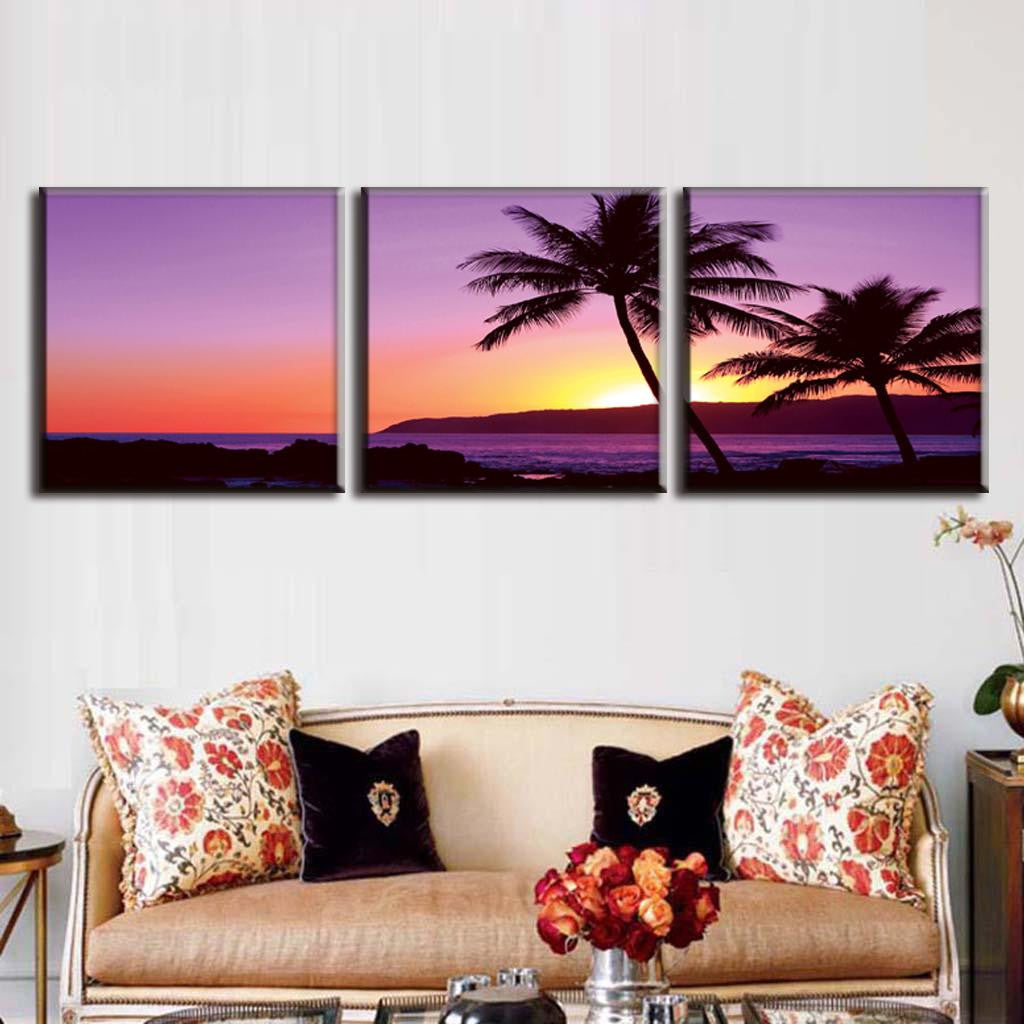 Purple Seascape Sunset canvas wall art featuring a tropical beach silhouette with palm trees against a vibrant purple and orange sky at dusk, ocean waves rolling onto shore, split into three panels for dramatic wall display