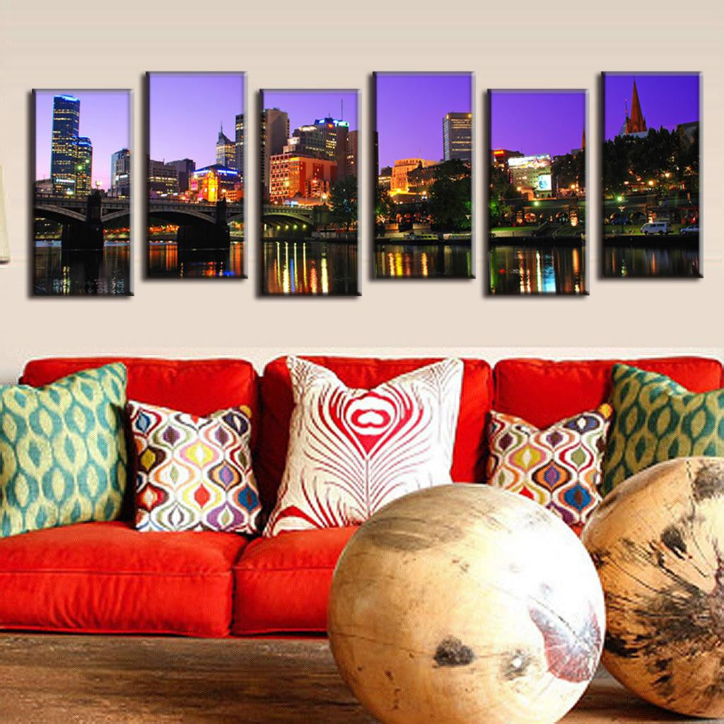 Cityscape Reflection on the Lake: Six-panel canvas wall art displaying illuminated urban skyline at night with vibrant city lights reflecting on calm water, featuring modern buildings, bridge, and church spire against purple twilight sky