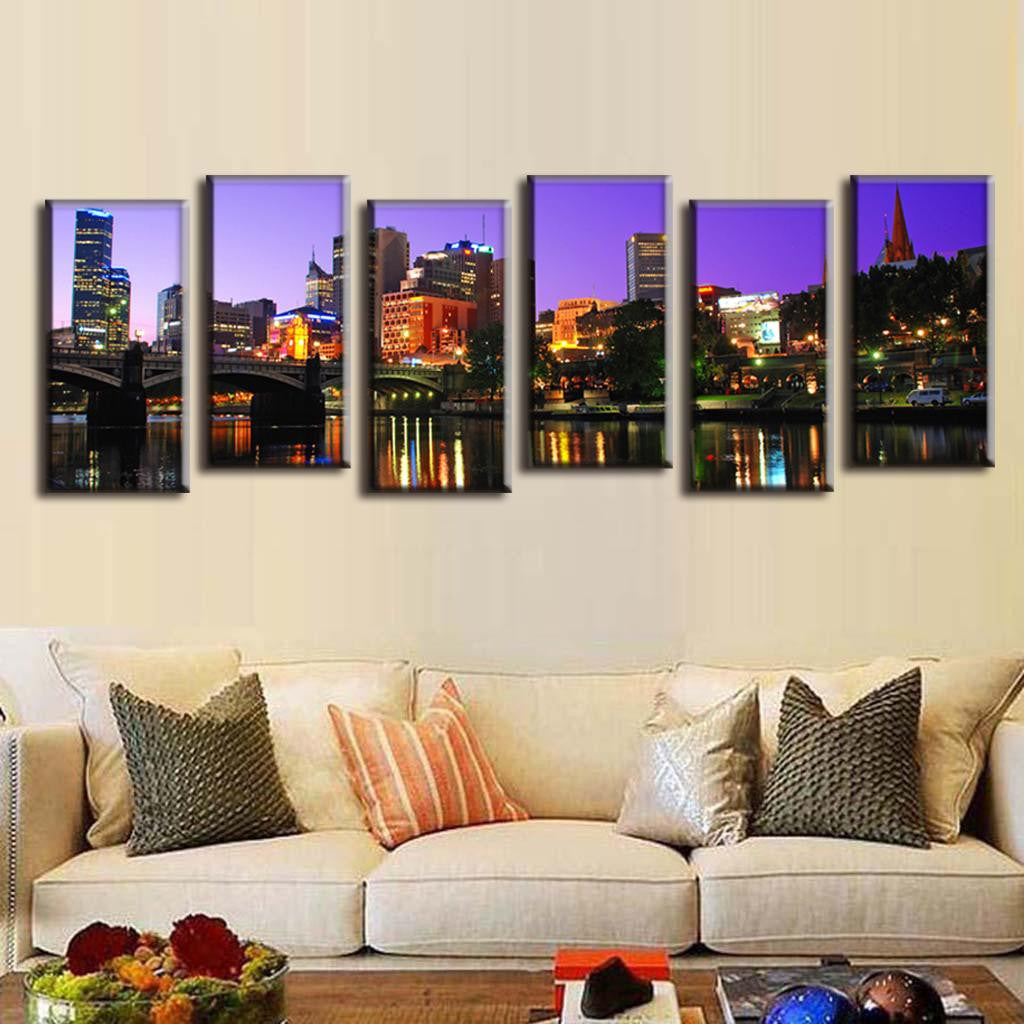 Cityscape Reflection on the Lake - 6-panel canvas wall art displaying illuminated urban skyline at twilight with vibrant purple sky, colorful building lights reflecting in calm water, perfect modern home decor measuring 72x24 inches