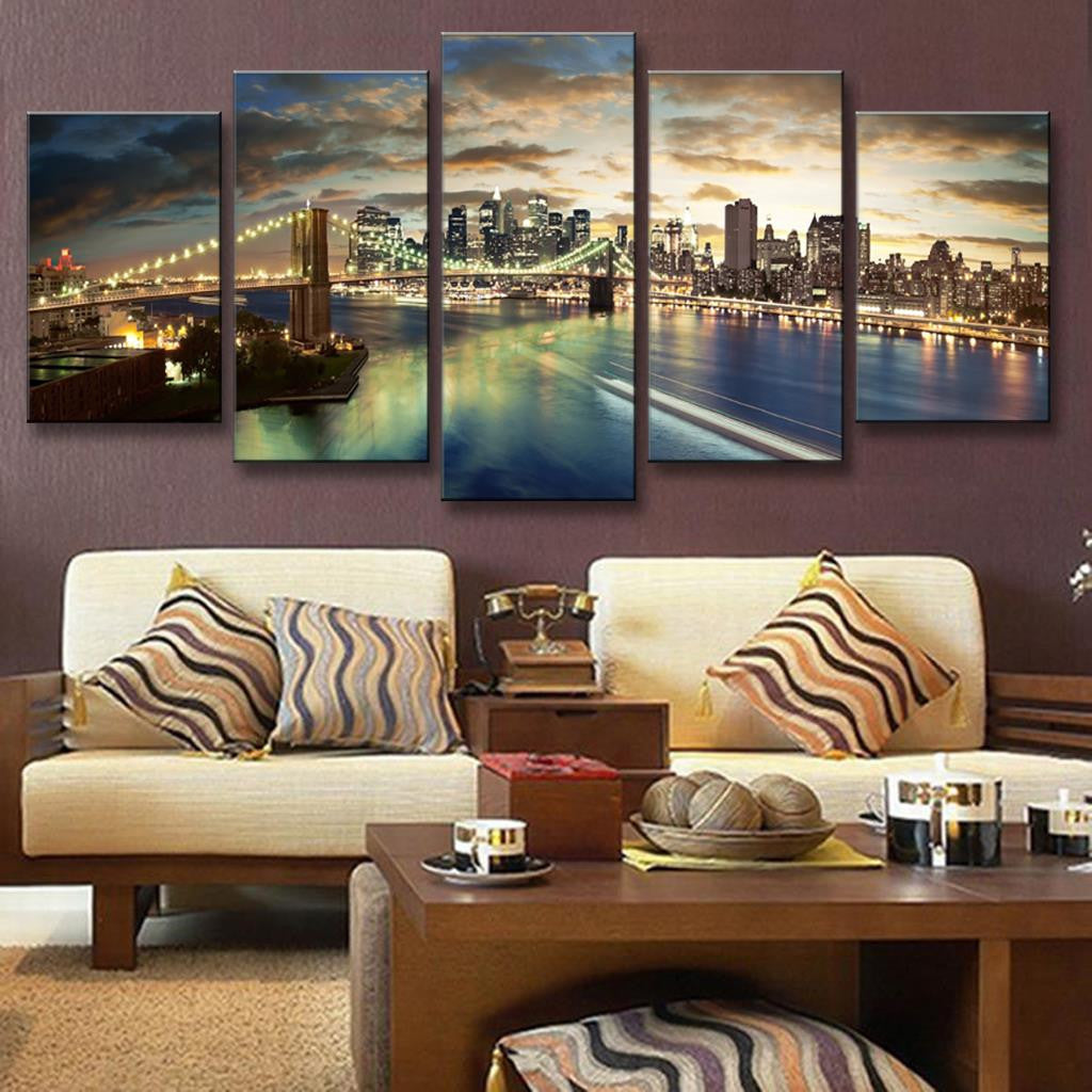 The Brooklyn Bridge Night Scene - Stunning cityscape canvas art showing illuminated Brooklyn Bridge, glowing Manhattan skyline, and East River reflections at dusk with dramatic clouds and city lights creating a mesmerizing panoramic view