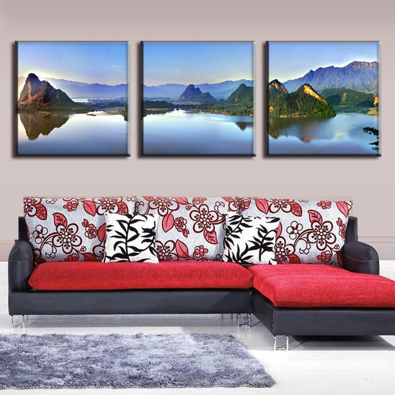 Lake and Mountain Landscape: Serene triptych canvas wall art featuring a tranquil mountain lake reflecting majestic peaks at sunrise, showcasing peaceful blue waters and dramatic mountain silhouettes across three panels