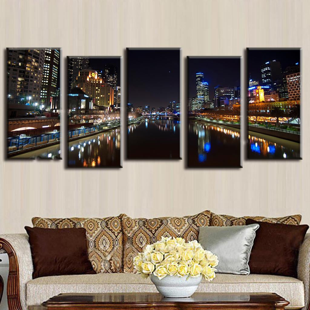 Cityscape at Night with Reflection: 5-panel canvas wall art showing illuminated urban skyline with dramatic mirror reflections in river water, featuring glowing skyscrapers, city lights, and waterfront against dark night sky, perfect for modern home decor