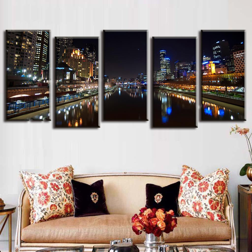 Cityscape at Night with Reflection - 5-panel canvas wall art showing illuminated urban skyline mirrored in calm river waters, featuring glowing skyscrapers, city lights, and waterfront promenade creating stunning symmetrical reflections