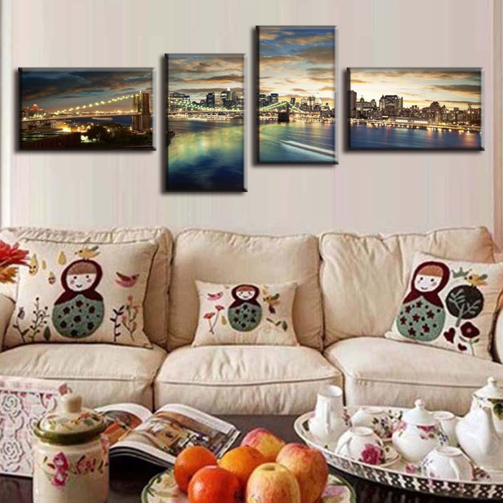 Brooklyn Panoramic at Night - 4-panel canvas wall art displaying illuminated Brooklyn Bridge and Manhattan skyline reflecting on East River waters at dusk, with dramatic cloudy sunset sky above the cityscape.