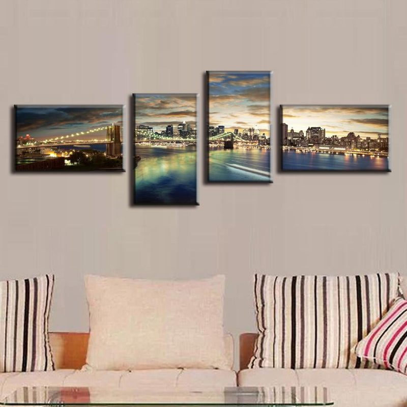 Brooklyn Panoramic at Night - 4-piece canvas wall art showcasing illuminated Brooklyn Bridge and Manhattan skyline reflecting on East River waters at dusk, with dramatic sunset clouds and city lights creating a stunning urban panorama