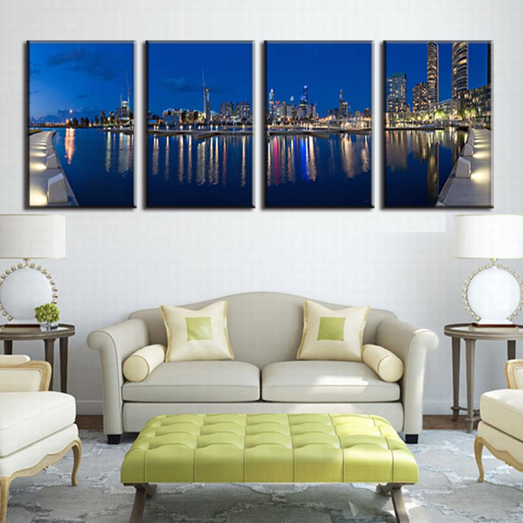 Blue City Night - 4 panel canvas wall art featuring illuminated cityscape reflected in calm waterfront, displaying modern skyscrapers and urban lights against deep blue twilight sky