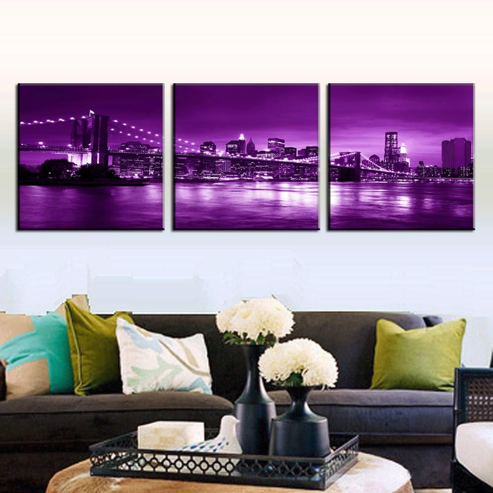 Brooklyn Bridge in Purple Night - stunning 3-panel canvas wall art featuring iconic New York City skyline and bridge illuminated in vibrant purple hues reflecting on East River at twilight