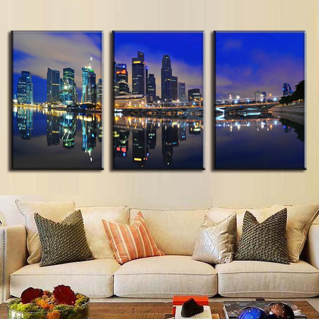 Modern City at Night - stunning 3-panel canvas wall art featuring illuminated skyscrapers reflecting on calm water at twilight, with deep blue sky and city lights creating a mesmerizing mirror effect