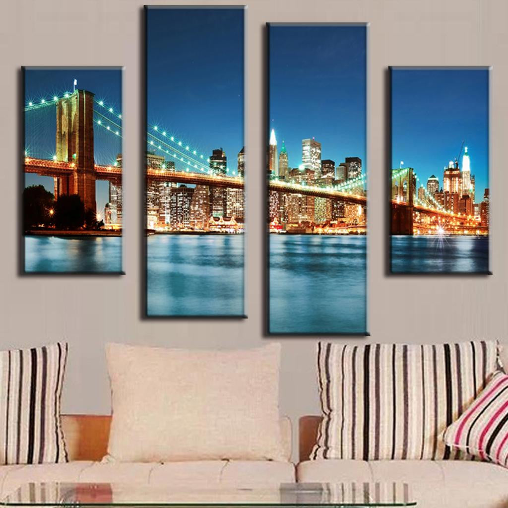 Brooklyn Bridge in Blue Night - stunning 4-panel canvas art featuring illuminated Brooklyn Bridge and Manhattan skyline reflecting on East River waters at twilight with city lights glowing