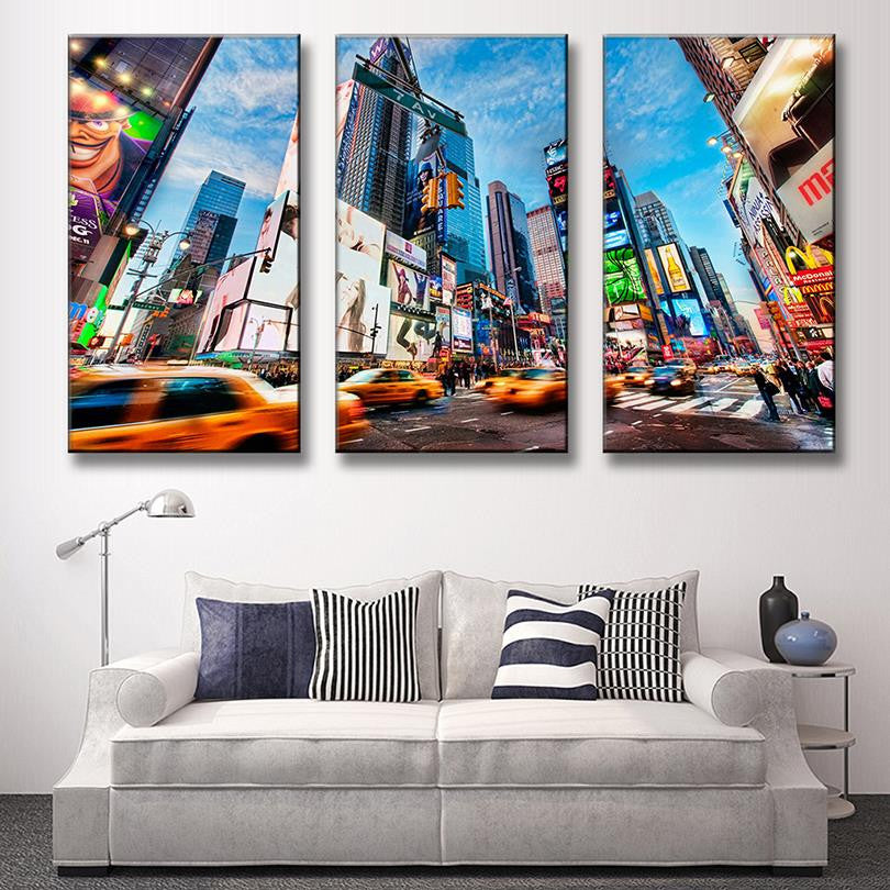 City Landscape - Vibrant three-panel canvas art featuring New York Times Square with yellow taxis, towering skyscrapers, bright billboards, and bustling city life against a vivid blue sky. Modern urban wall decor set.