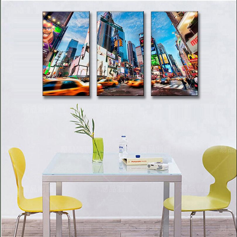 City Landscape canvas art showing vibrant Times Square New York with yellow taxis in motion, towering skyscrapers, bright digital billboards, and bustling street scene split across three panels under blue sky