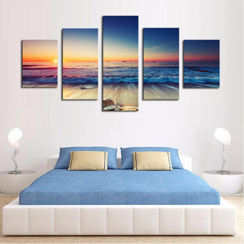 Waves and Sunset Scene: 5-piece canvas wall art displaying vibrant ocean waves crashing on beach during golden sunset, with blue-orange gradient sky and tranquil seascape perfect for bedroom decor