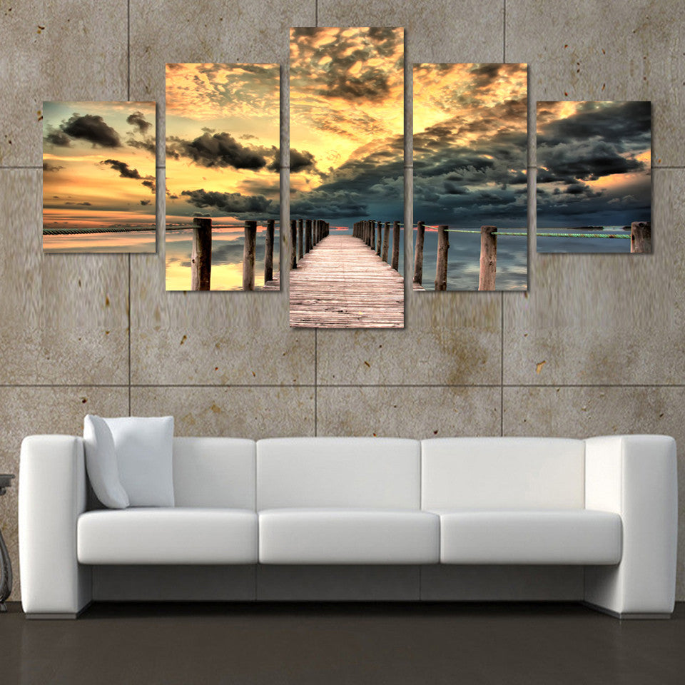 Dock and Seascape: Dramatic 5-panel canvas wall art featuring wooden pier extending into ocean at sunset, with golden clouds and stormy skies creating stunning coastal scene perfect for home decor